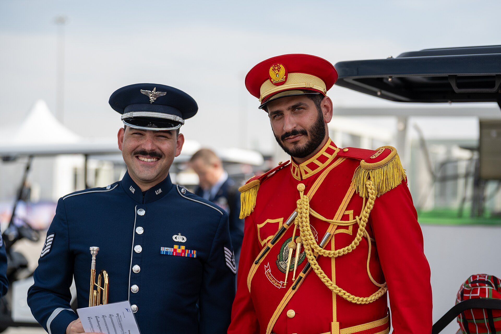 U.S. Air Force Tech. Sgt. Jack Kurtz, 9th Air Force (Air Forces Central) Band trumpeter, and a United Arab Emirates Armed Forces Band member pose for a photo during the Dubai Airsh
