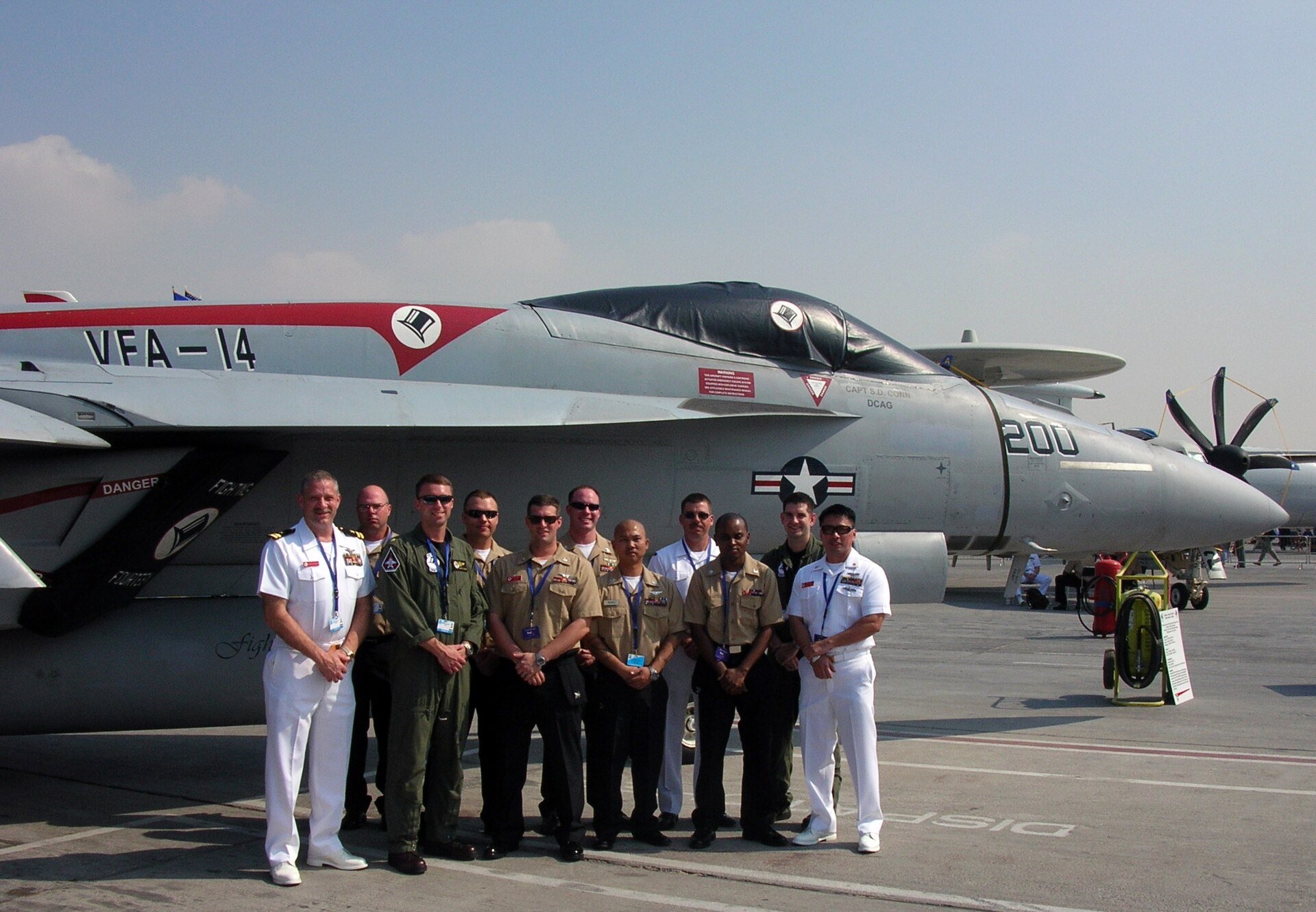 Aviators and maintainers from the "Top Hatters" of Strike Fighter Squadron 14 pose for a photo in front of an F/A-18E Super Hornet static display at the 2009 Dubai International Ai