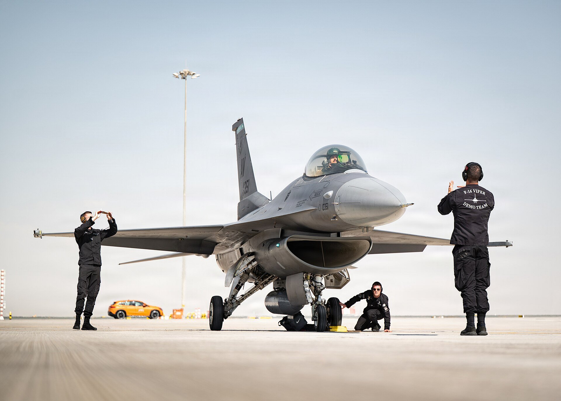 A U.S. Air Force F-16C Fighting Falcon assigned to the 31st Fighter Squadron at Aviano Air Base, Italy, is marshalled by U.S. Air Force F-16 Viper Demonstration Team crew chiefs fo
