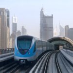 Train south of the Burj Khalifa/Dubai Mall Dubai Metro Red Line station looking north in Dubai, United Arab Emirates, with highrise buildings in the background.