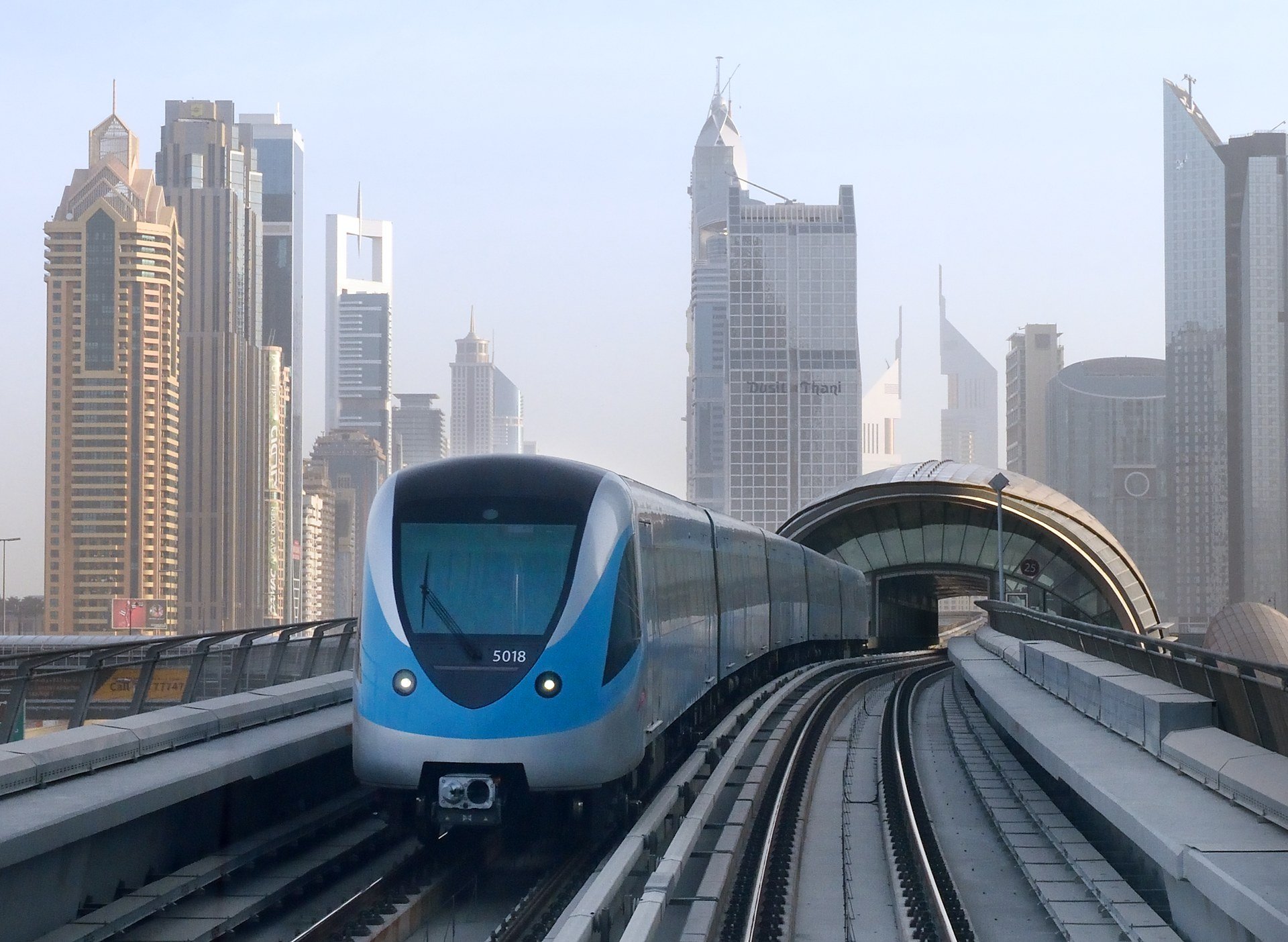 Train south of the Burj Khalifa/Dubai Mall Dubai Metro Red Line station looking north in Dubai, United Arab Emirates, with highrise buildings in the background.