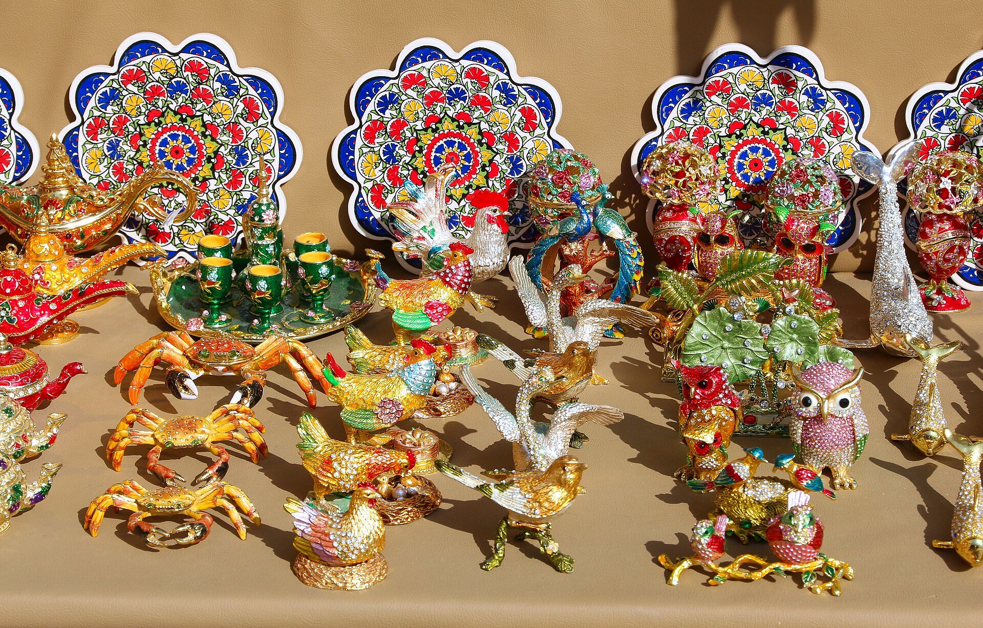 Kitchy, tacky, colorful souvenir knick knacks (figurines of roosters, hens, swans, songbirds, crabs and owls adorned with rhinestones and glitter) at a souk in Dubai, United Arab E