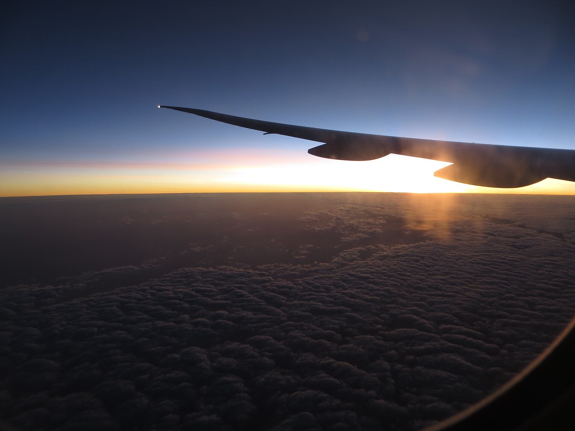 Wing view of an Emirates Boeing 777-300ER registered A6-EGO. Sunrise viewed on Flight 564 from Dubai DXB to Bengaluru BLR