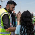 A Dubai Airshow staff member holds a microphone while a student asks a question during the Dubai Airshow 2025 Meet a Pilot question and answer session with U.S. Air Force pilots at